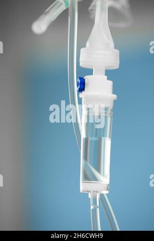 Nahaufnahme des Infusionsschlauchs. Aktion. Dropper mit Medikament tropft langsam in den Schlauch. Intravenöse Röhrchen für kranke Patienten nach der Operation Stockfoto