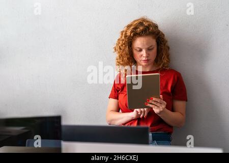Porträt einer glücklichen, erfolgreichen Frau, die im Büro auf einem digitalen Tablet websurft Stockfoto