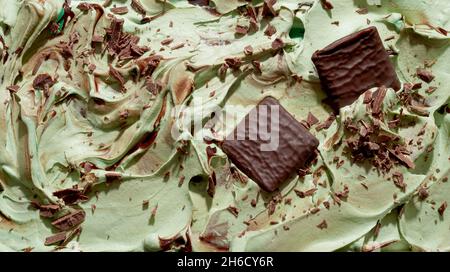 Köstliche Schokoladensplitter und Minze-Eiscreme im Vollformat mit Schokoladenflocken und Waffeln auf der Oberfläche von cremig-grünem Eis in Nahaufnahme Stockfoto
