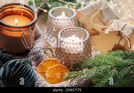 Adventsdekoration und Geschenkschachteln mit brennenden Kerzen. Weihnachten Hintergrund Stockfoto