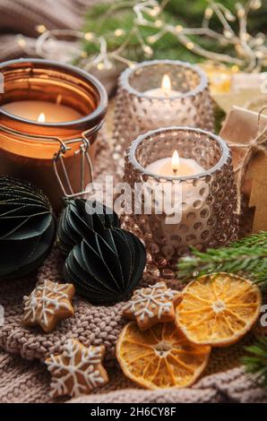 Adventsdekoration und Geschenkschachteln mit brennenden Kerzen. Weihnachten Hintergrund Stockfoto