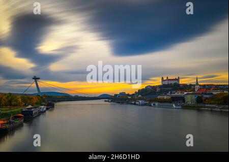 Sonnenuntergang über der Burg Bratislava, der Donau und der SNP-Brücke in der Slowakei Stockfoto