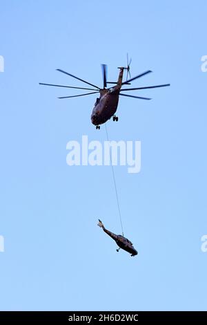 Transporthubschrauber Mi-26 T2B transportiert den Rumpf eines Kampfhubschraubers auf der externen Aufhängung. Schwerer Hubschrauber. Zur Kodifizierung von NAT Stockfoto