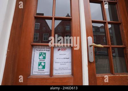 Potsdam, Deutschland. November 2021. Ein Schild, das die Einhaltung der 2G-Regel anzeigt, befindet sich an der Eingangstür eines Restaurants. In Brandenburg treten die strengeren Corona-Regeln in Kraft. Die 2G-Regel mit Zugang nur für geimpfte und wiedergeborene Personen wird für einige Gebiete obligatorisch, plus eine Maskenpflicht in Grundschulen. Quelle: Jörg Carstensen/dpa/Alamy Live News Stockfoto