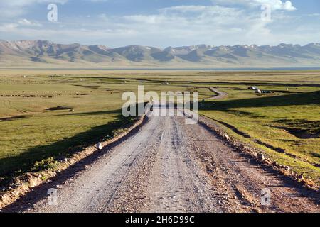 Unbefestigte Straße und Jurten in der Nähe von Son-Kul See und Tien shan Gebirge in Kirgisistan Stockfoto