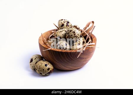 Isolieren Sie eine Holzschüssel mit Wachteleiern auf weißem Hintergrund, Nahaufnahme Stockfoto