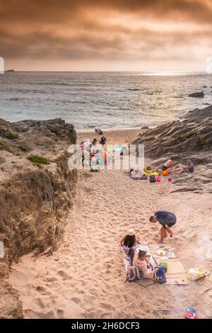 Urlauber genießen die späte Abendsonne am abgelegenen Strand von Little Fistral in Newquay in Cornwall. Stockfoto