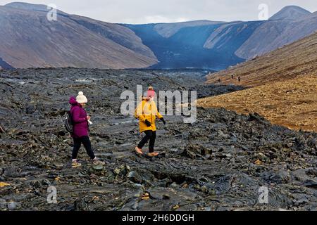 Zwei weibliche Touristen, die auf gekühltem Lavastrom laufen, Island, Reykjanes Peninsula, Fagradalsfjall Stockfoto