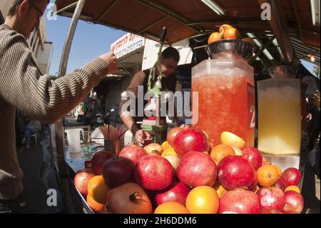 Granatapfel, Anar (Punica granatum), Granatäpfel mit Blutorangen auf einem Saftextraktor auf dem Carmel-Markt, Israel, Tel Aviv Stockfoto