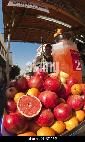 Granatapfel, Anar (Punica granatum), Granatäpfel mit Blutorangen auf einem Saftextraktor auf dem Carmel-Markt, Israel, Tel Aviv Stockfoto