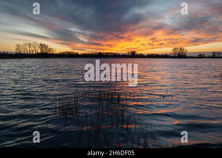 Farbenfroher Sonnenuntergang mit Wolken über dem See, Stankow, Lubelskie, Polen Stockfoto