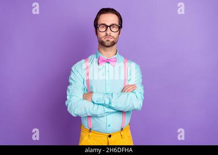 Foto von strengen Millennial Brunet Mann gekreuzte Arme tragen Krawatte Hosenträger Hemd Brille isoliert auf violettem Hintergrund Stockfoto