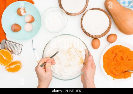 Schritt-für-Schritt-Rezept für Kürbiskuchen Kasserolle in Form eines Zebras, orangefarbener Herbstkuchen mit Orange. Mischzutaten für Kürbiskuchen Draufsicht. Stockfoto