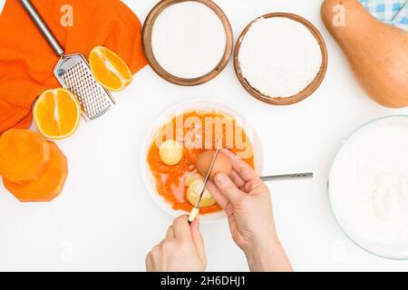 Schritt-für-Schritt-Rezept für Kürbiskuchen Kasserolle in Form eines Zebras, orangefarbener Herbstkuchen mit Orange. Mischzutaten für Kürbiskuchen Draufsicht. Stockfoto