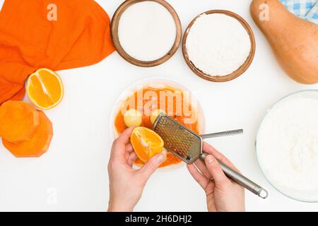 Schritt-für-Schritt-Rezept für Kürbiskuchen Kasserolle in Form eines Zebras, orangefarbener Herbstkuchen mit Orange. Mischzutaten für Kürbiskuchen Draufsicht. Stockfoto