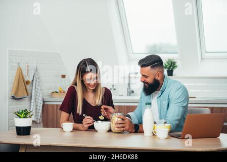 Eine kleine Aufnahme eines jungen, schönen Paares, das zu Hause frühstückte Stockfoto