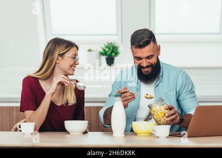 Eine kurze Aufnahme eines jungen Paares, das zu Hause frühstücken und seine Freizeit zusammen verbringen will Stockfoto