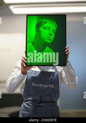 Ein Mitarbeiter von Bonhams hält ein Hologramm-Kunstwerk mit Glasplatte, das Noel Gallagher aus Oasis, 1997, von Rob Munday, mit einer Schätzung von Â£bis 1,500 1,000 zeigt, während eines Fotoaufrufs für Highlights aus Bonhams' Film-, Rock- und Pop-Verkauf, einschließlich Immobilien aus dem Nachlass von Dame Diana Rigg, In Bonhams, London. Bilddatum: Montag, 15. November 2021. Stockfoto