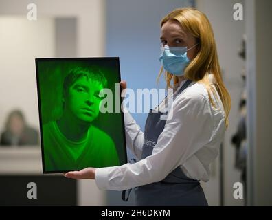 Ein Mitarbeiter von Bonhams hält ein Hologramm-Kunstwerk mit Glasplatte, das Noel Gallagher aus Oasis, 1997, von Rob Munday, mit einer Schätzung von £bis 1,500 1,000 zeigt, während eines Fotoaufrufs für Highlights aus Bonhams' Film-, Rock- und Pop-Verkauf, einschließlich Immobilien aus dem Nachlass von Dame Diana Rigg, In Bonhams, London. Bilddatum: Montag, 15. November 2021. Stockfoto