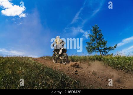 Zurück männlichen Biker in Enduro Motorrad Reiten auf Bergpfad Stockfoto