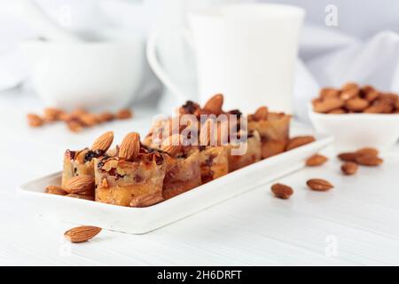 Kleine Kuchen mit Mandeln, Rosinen und Honig auf einem weißen Tisch. Stockfoto