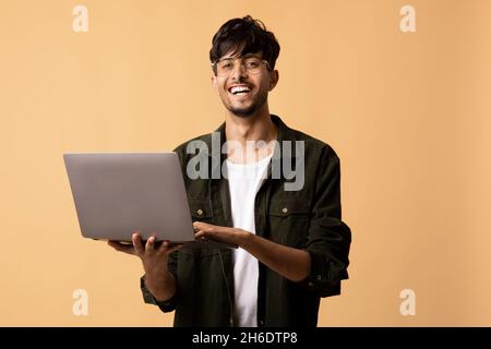 Glücklich indischen Kerl Freiberufler mit modernen Laptop, Programmierung Stockfoto