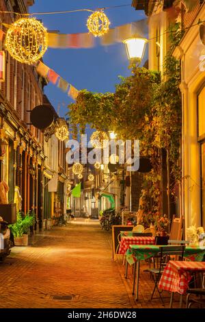 Bunte Einkaufsstraße mit weihnachtlicher Dekoration im alten Stadtzentrum von Alkmaar, Niederlande Stockfoto