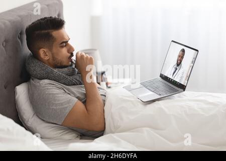 Telemedizin. Kranker Mann Mit Laptop Zu Hause, Mit Videoanruf Mit Arzt Stockfoto