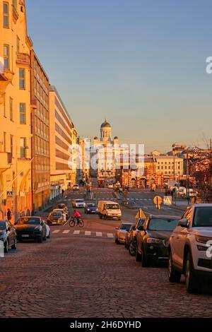 Autos und langsamer Verkehr in Eteläranta, Helsinki, Finnland in der goldenen Stunde eines sonnigen Novembermorgens. Die Kathedrale von Helsinki im Hintergrund. 2021. Stockfoto