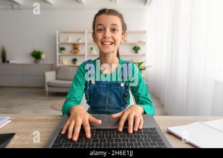 Mädchen sitzt am Tisch mit Laptop, Webcam pov Stockfoto