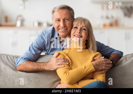 Glückliches Senior-Paar, Das Zu Hause Auf Dem Sofa Sitzt Stockfoto