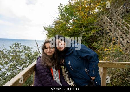 Eine Mutter und Tochter lächeln auf einem Holzbalkon auf die Kamera. Bild von Mons Klint in Dänemark Stockfoto