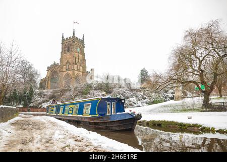 Vorderansicht eines Schmalboots auf einem britischen Kanal, das sich im Winter der Kidderminster-Schleuse nähert und Schnee auf dem Boden hat. Stockfoto