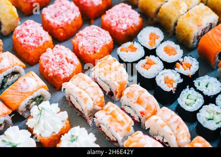 Verschiedene Arten von Sushi-Rollen mit Lachs, Garnelen, Käse und Kaviar. Stockfoto