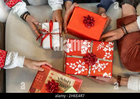 Gruppe junger Freunde tauschen weihnachtsgeschenke auf dem Sofa aus - Konzept der Weihnachtsstimmung Stockfoto