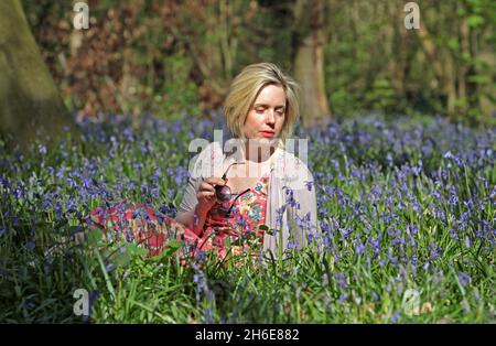 Eine Frau genoss an diesem Wochenende die frühen Bluebells im Wanstead Park im Osten Londons. In der Regel im Park bis Ende April gesehen, haben diese Jahre Ernte früh aufgrund der warmen Zauber des Wetters blühte. Der National Trust prognostizierte letzte Woche, dass Bluebells in ganz Großbritannien nach dem milden und trockenen Start ins Jahr 2011 mehr als einen Monat früher als im letzten Jahr blühen würden. Stockfoto