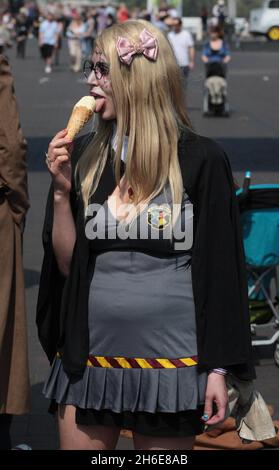 Ein hogwarts-Fan kühlt sich mit einem Eis ab, als sie heute Nachmittag an der Sci FI Osterparade in London teilnahm. Die alternative Parade fand vom BFI (British Film Institute) South Bank entlang der Themse zum London Film Museum statt und umfasste Zombies, Sturmtruppen und Superhelden, die Teil des London Sci Fi 2011 Festivals waren. Stockfoto