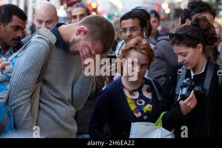 Steve Jobs stirbt – Ein Mann weint heute Abend vor dem Apple-Store in der Londoner Regent Street, während die Massen die Tribute ansehen, die für den Mitbegründer von Apple, Steve Jobs, hinterlassen wurden. Stockfoto