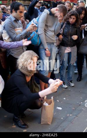 Steve Jobs stirbt – Ein Mann weint heute Abend vor dem Apple-Store in der Londoner Regent Street, während die Massen die Tribute ansehen, die für den Mitbegründer von Apple, Steve Jobs, hinterlassen wurden. Stockfoto