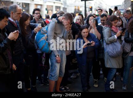 Steve Jobs stirbt – Ein Mann weint heute Abend vor dem Apple-Store in der Londoner Regent Street, während die Massen die Tribute ansehen, die für den Mitbegründer von Apple, Steve Jobs, hinterlassen wurden. Stockfoto