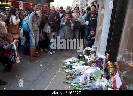 Steve Jobs stirbt – Ein Mann weint heute Abend vor dem Apple-Store in der Londoner Regent Street, während die Massen die Tribute ansehen, die für den Mitbegründer von Apple, Steve Jobs, hinterlassen wurden. Stockfoto