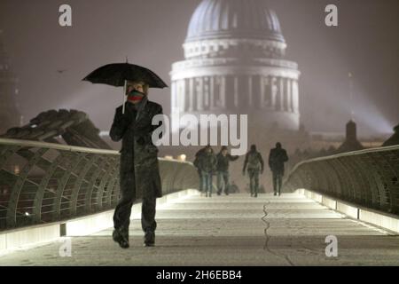 Letzte Nacht fiel Schnee auf der Millennium-Brücke neben der St. Paul's Cathedral in London Stockfoto