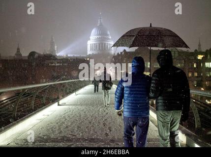 Letzte Nacht fiel Schnee auf der Millennium-Brücke neben der St. Paul's Cathedral in London Stockfoto