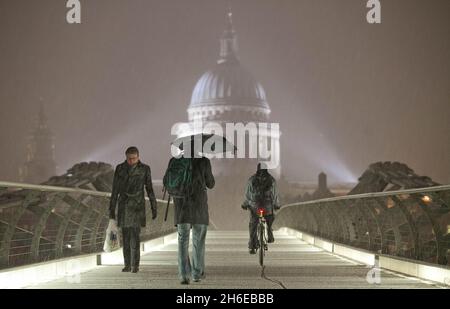 Letzte Nacht fiel Schnee auf der Millennium-Brücke neben der St. Paul's Cathedral in London Stockfoto