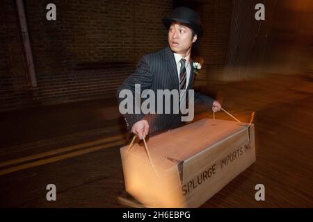 Future Cinema hat den Hit BUGSY MALONE in die fabelhafte Troxy in East London zurückgebracht. Fans sind eingeladen, in die Welt der Prohibition-Ära Chicago einzutreten, während Fat Sam eine alles singende, tanzende Extravaganz präsentiert. Es gibt Cola-Schwimmer, Boxen, tanzende Mädchen, Gangster und Pudding Pie werfen eine Menge. Stockfoto