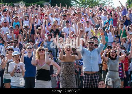 Die Fans auf dem Murray Mound feiern, wie der britische Andy Murray den serbischen Novak Djokovic besiegt und das Wimbledon Men's Final gewinnt. Stockfoto