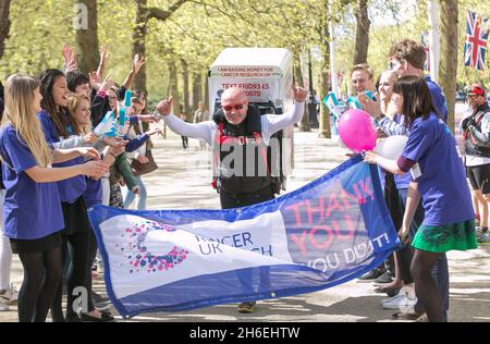 Charity-Läufer Tony Phoenix-Morrison, bekannt als Tony the Fridge on the Mall, als er die London Marathons hinter sich führt, während er einen Kühlschrank trägt. Stockfoto