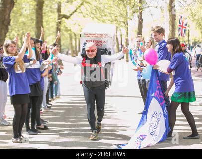 Charity-Läufer Tony Phoenix-Morrison, bekannt als Tony the Fridge on the Mall, als er die London Marathons hinter sich führt, während er einen Kühlschrank trägt. Stockfoto