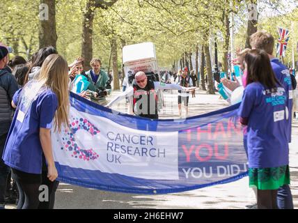 Charity-Läufer Tony Phoenix-Morrison, bekannt als Tony the Fridge on the Mall, als er die London Marathons hinter sich führt, während er einen Kühlschrank trägt. Stockfoto