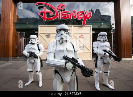 Stormtroopers und R2-D2 schlossen sich einem jungen Star Wars-Fan an, der als Prinzessin Leia Daisy im Alter von 8 Jahren im Disney Store in der Oxford Street gekleidet war, um den finalen Countdown bis Mitternacht zu beginnen, als die mit Spannung erwartete Star Wars: The Force Awakens-Produktlinie am 4. September auf den Markt kommt. Stockfoto